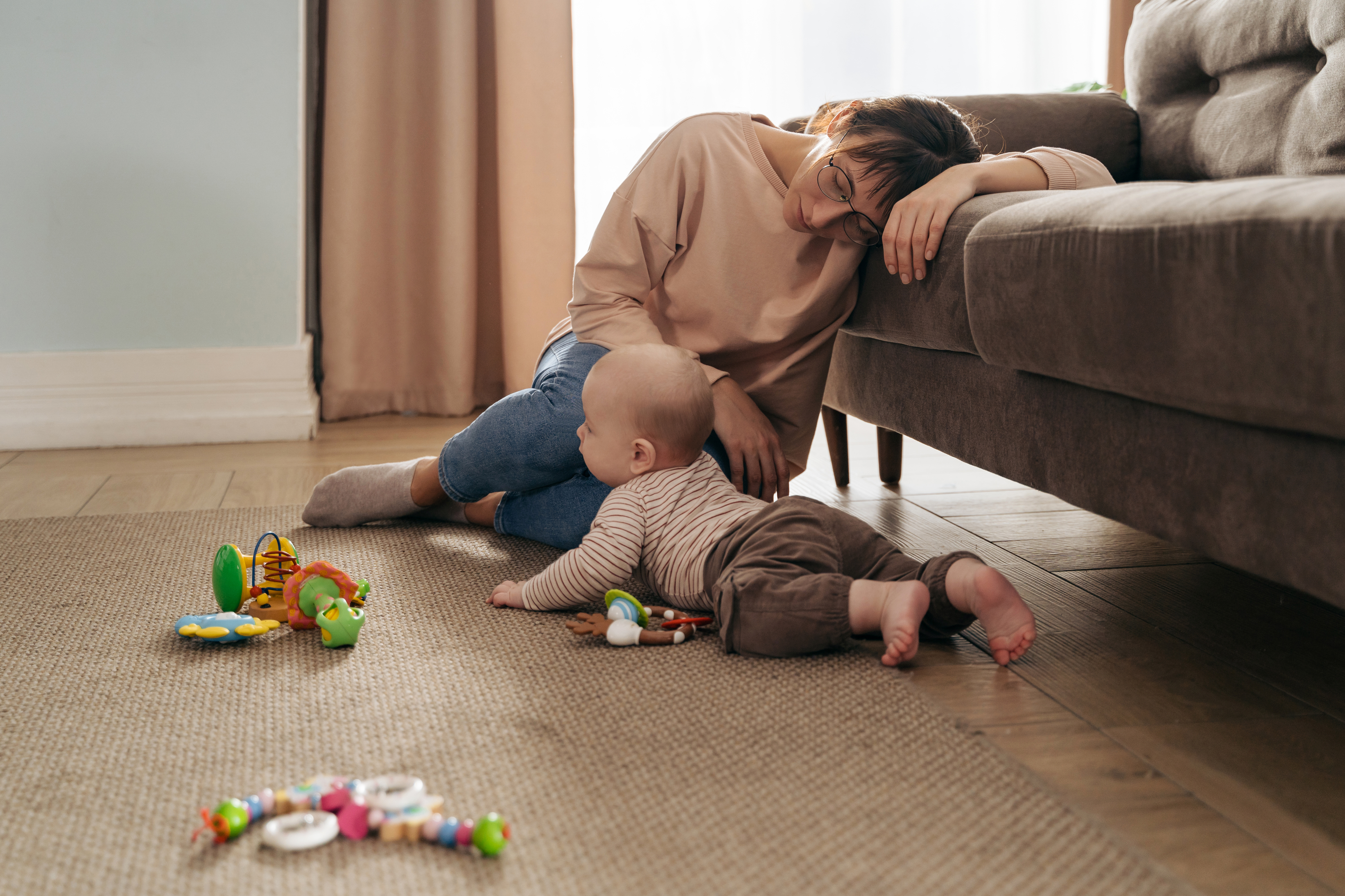 A person and baby lying on the floorDescription automatically generated